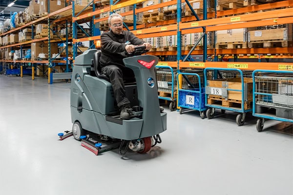 Geautomatiseerde schoonmaakrobot in magazijn voor efficiënte reiniging en onderhoud.